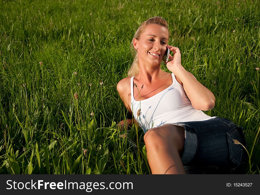 Young woman communicates by phone outdoors. Young woman communicates by phone outdoors