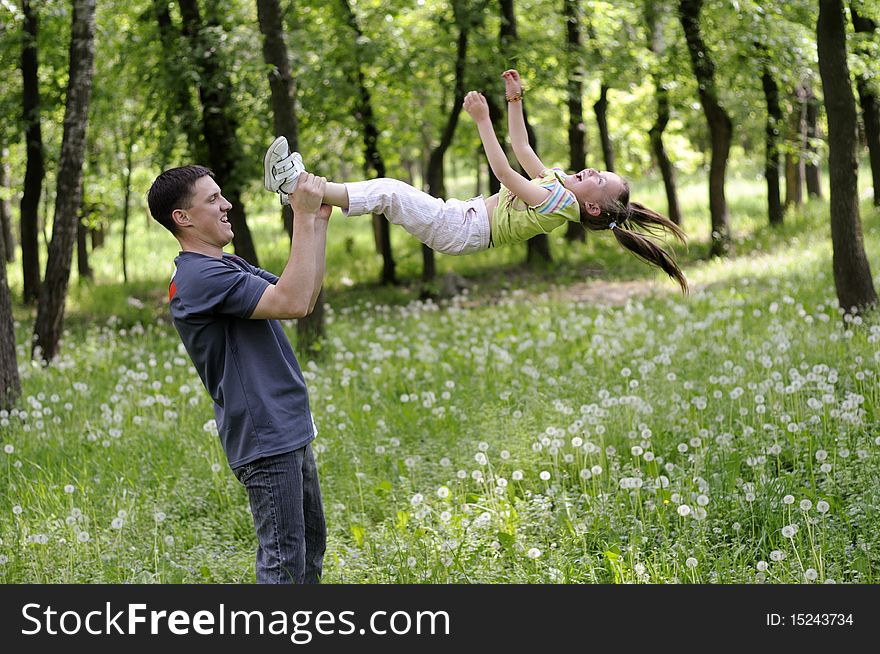 The young father is played with the small daughter a green lawn. The young father is played with the small daughter a green lawn