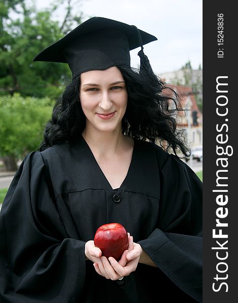 Caucasian student girl in gown with apple