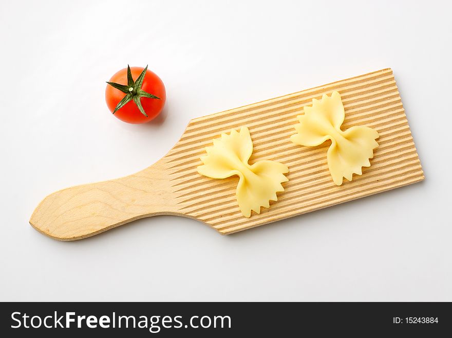 Bowtie pasta on a wooden cutting board. Bowtie pasta on a wooden cutting board