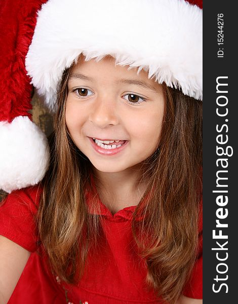 Cute brunette girl wearing a fluffy christmas hat. Cute brunette girl wearing a fluffy christmas hat