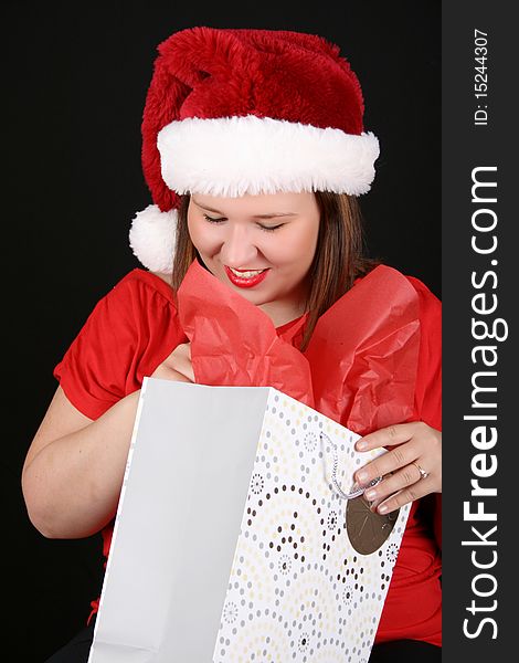 Beautiful caucasian brunette looking inside her christmas gift bag