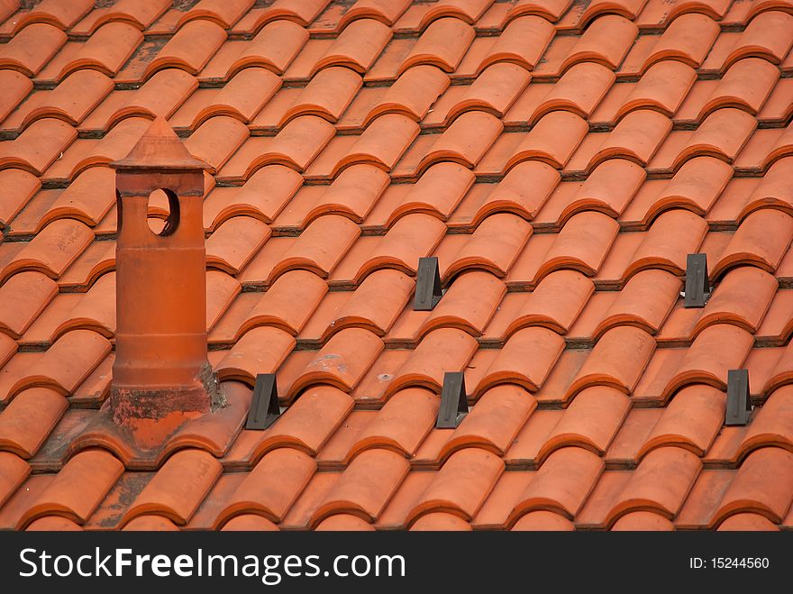 Chimney on the roof with red tiles