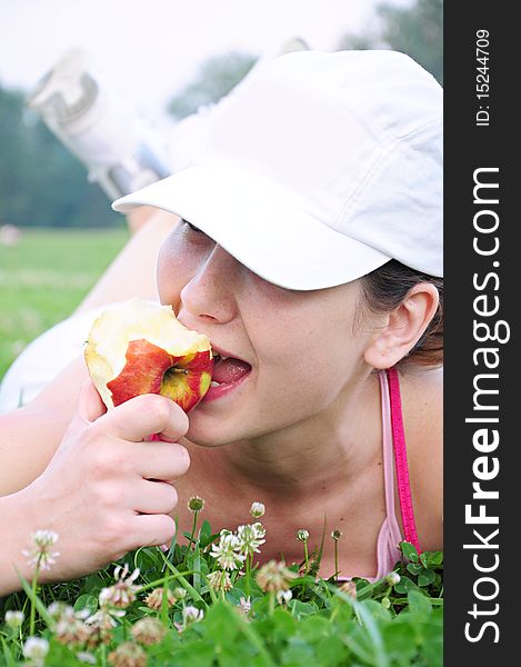 Girl lying on the grass and eat an apple. Girl lying on the grass and eat an apple