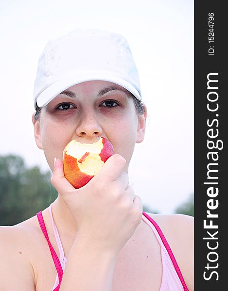 Girl Eating An Apple In Nature