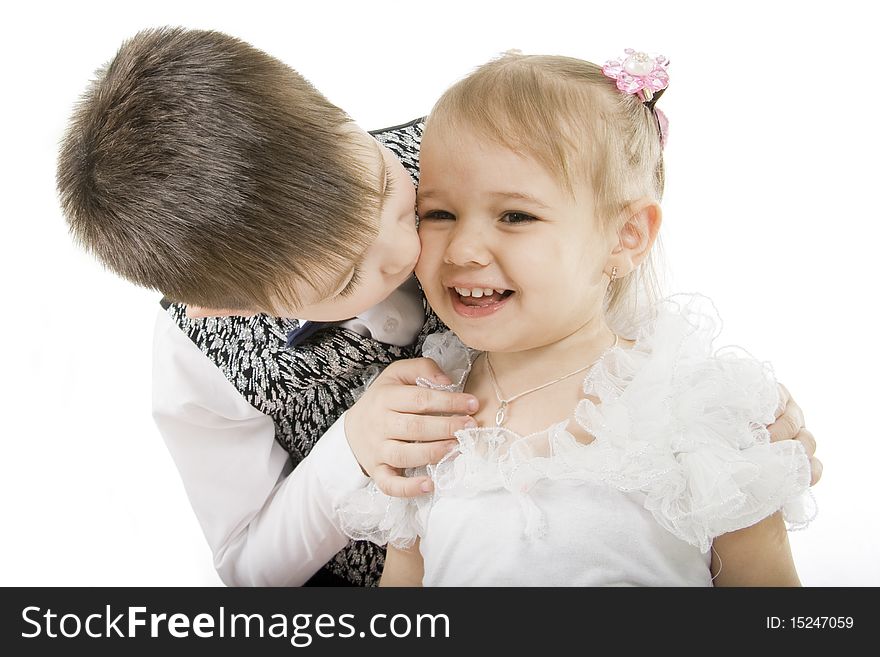 Small the boy kisses sister on a white background. Small the boy kisses sister on a white background