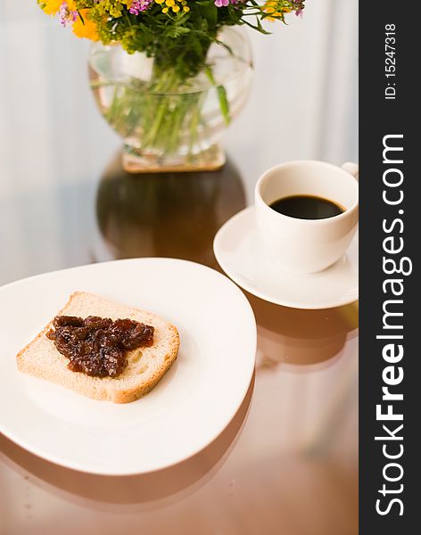 Romantic breakfast with coffee and bread with jam in a heart figure