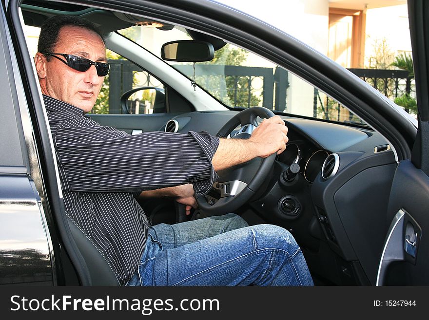 Man in new black car. Man in new black car.