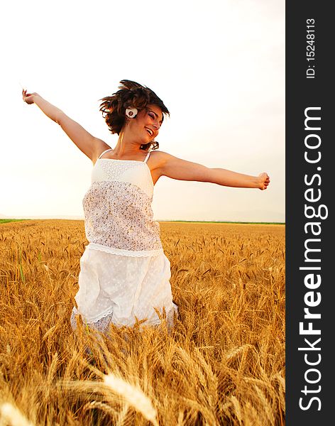 Young beautiful girl jumping in the middle of the cornfield