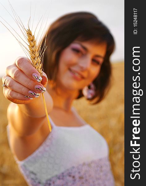 Young beautiful girl showing a corn with her hand