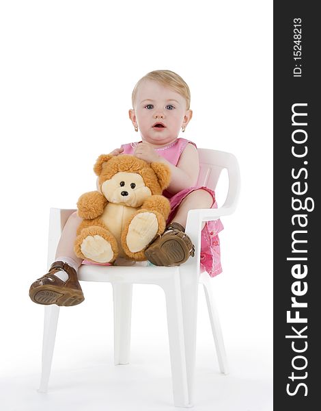 Toddler with his toy on stool on white background.