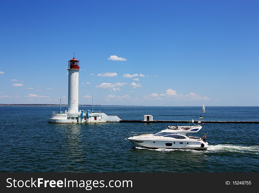 Luxury white speed boat near the lighthouse. Luxury white speed boat near the lighthouse