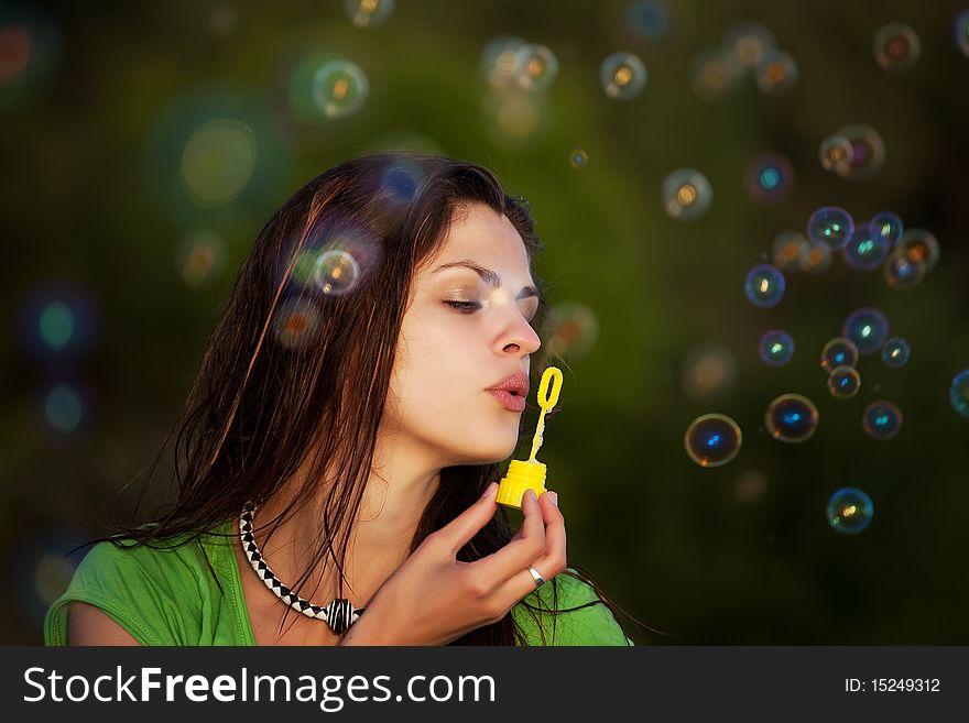 Young girl blowing soap bubbles