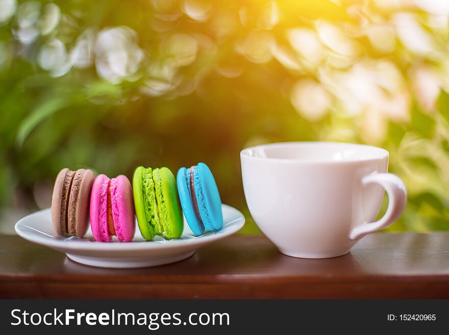 Valentine macaroons with coffee on wooden table. Toned image