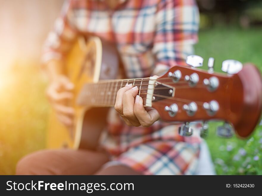 Young hipster woman playing guitar to relaxing on his holiday, enjoy with natural and fresh air