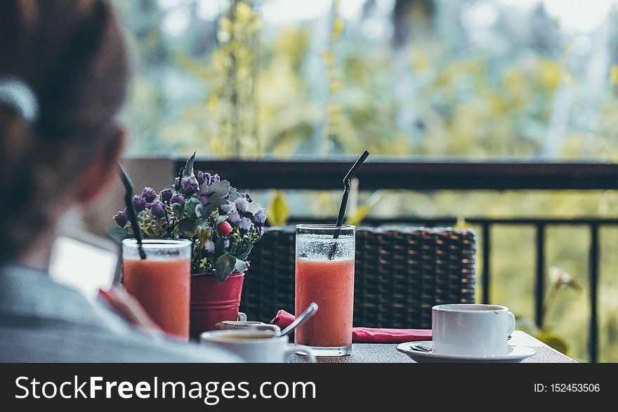 Young woman drinking a cup of coffee in the morning with the jungle view during luxury vacation in Bali island. Indonesia.