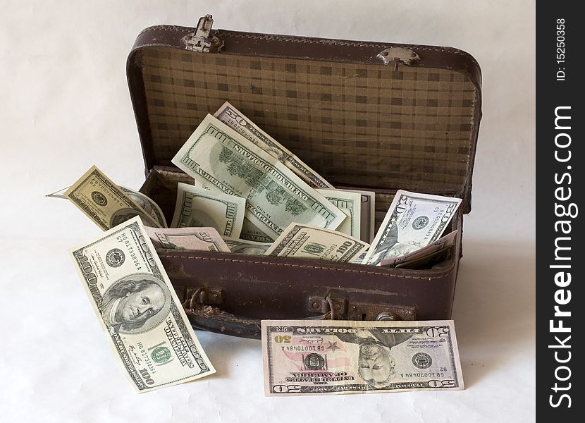 One hundred dollar and fifty dollar notes are in an old suitcase. One hundred dollar and fifty dollar notes are in an old suitcase