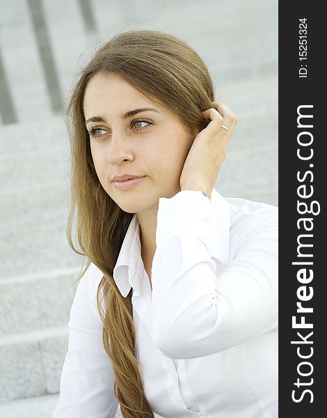 Portrait of a young specialist smiles on the background of the stairs and office space, and her hair / hairstyle. Portrait of a young specialist smiles on the background of the stairs and office space, and her hair / hairstyle