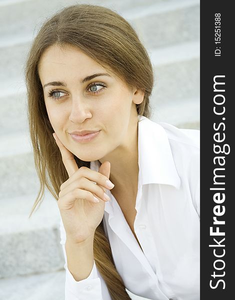 Portrait of a young specialist smiles on the background of the stairs and office space. Thinks. Portrait of a young specialist smiles on the background of the stairs and office space. Thinks