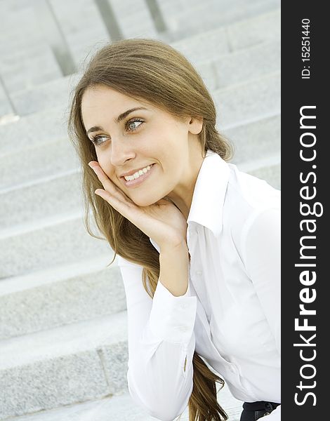 Portrait of a young specialist smiles on the background of the stairs and office space. Portrait of a young specialist smiles on the background of the stairs and office space