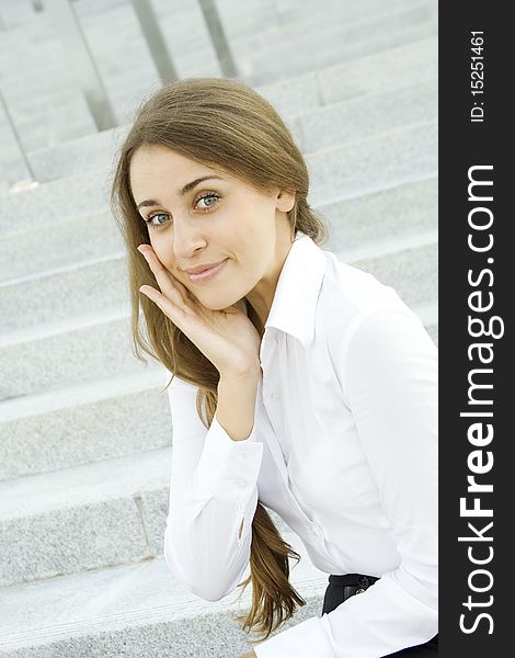 Portrait of a young specialist smiles on the background of the stairs and office space. Portrait of a young specialist smiles on the background of the stairs and office space