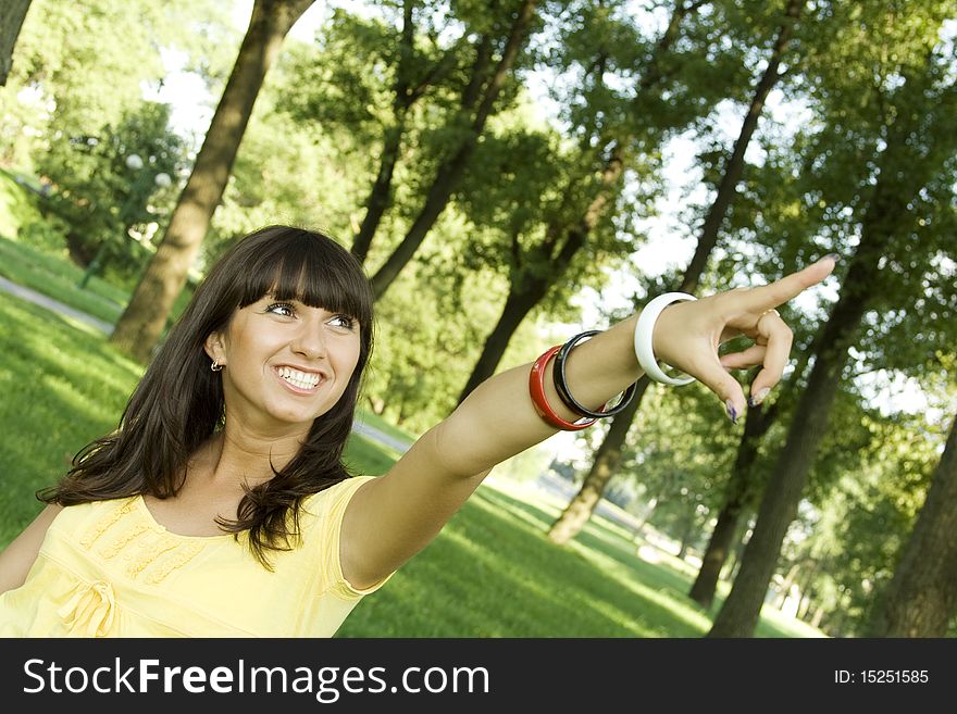 Young beautiful woman is in the park laughing and said, pointing upwards. Young beautiful woman is in the park laughing and said, pointing upwards