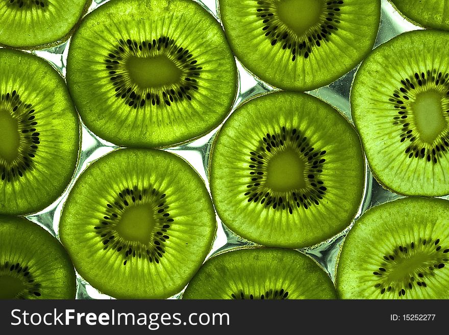 Sliced kiwi on the glass with flowing water. Sliced kiwi on the glass with flowing water