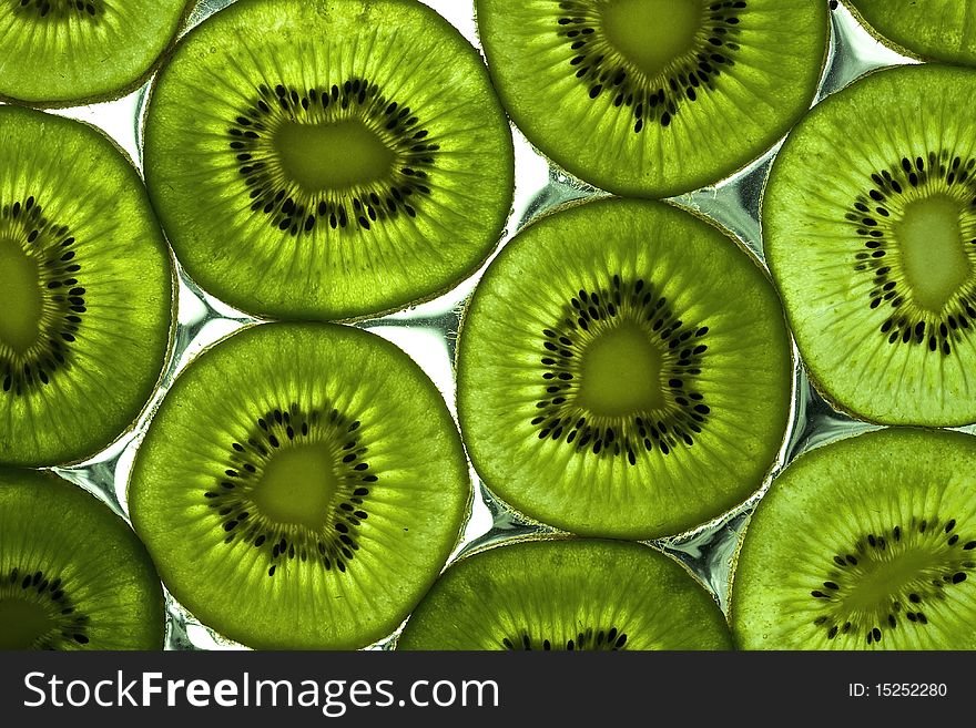 Sliced kiwi on the glass with flowing water. Sliced kiwi on the glass with flowing water