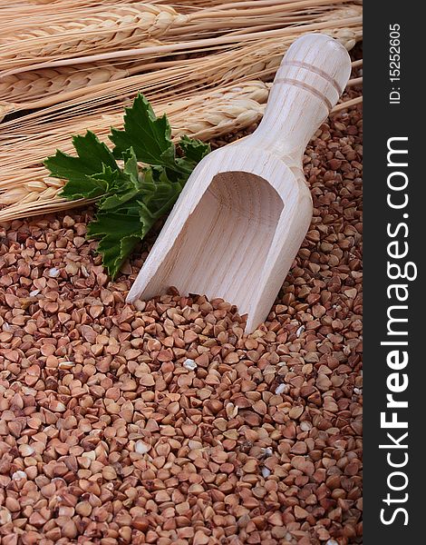 Buckwheat groats with a wooden deep spoon for packaging.