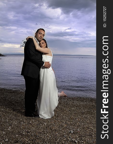 Wedding couple by the sea, dramatic sky