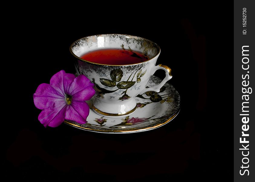 Cup of red tea and flower in black background. Cup of red tea and flower in black background