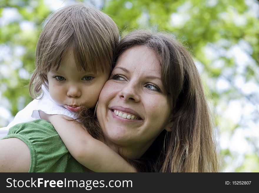Mother Holding Daughter Outdoors Smiling