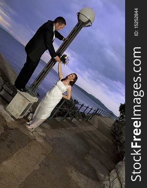 Wedding couple by the sea, dramatic sky