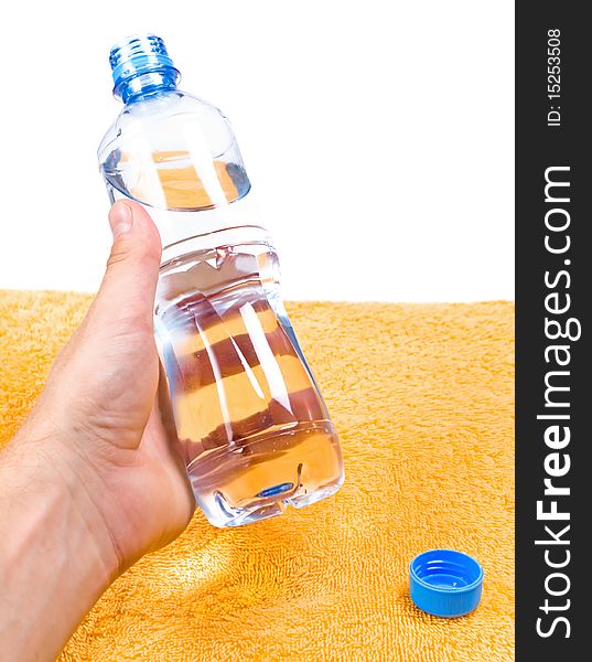 Hand holding water in blue bottle over orange background, fitness concept. Hand holding water in blue bottle over orange background, fitness concept