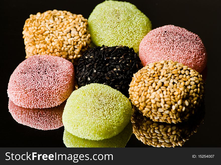 Assorted candies with reflection on black background