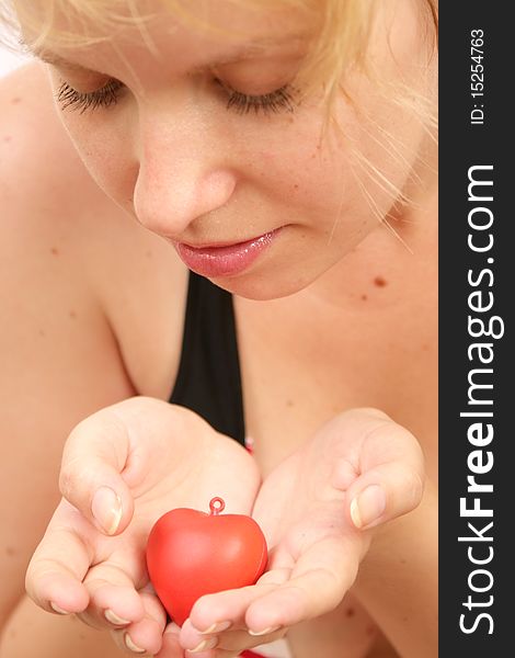 Blond girl holding a heart in hands