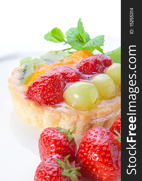 Frtuit tart with strawberries, grapes and kiwi, served with mint. Frtuit tart with strawberries, grapes and kiwi, served with mint