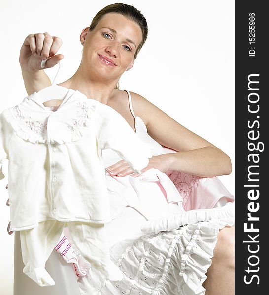 Pregnant woman with clothes for babies