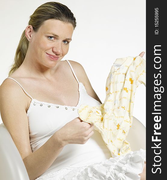 Pregnant woman with clothes for babies