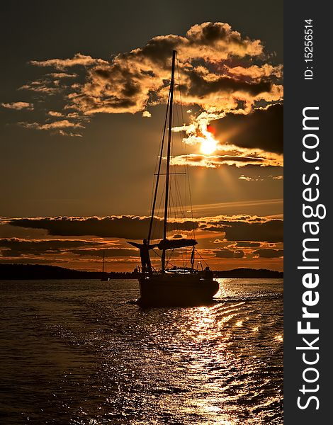 Yacht and sailor silhouette over coastline during sunset. Yacht and sailor silhouette over coastline during sunset.