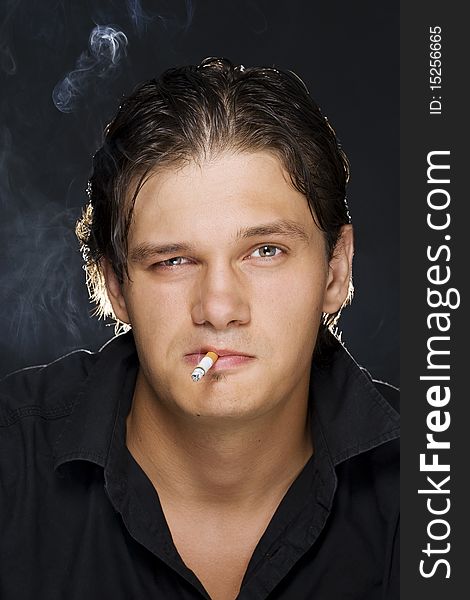 A portrait of a young man smoking a cigarette