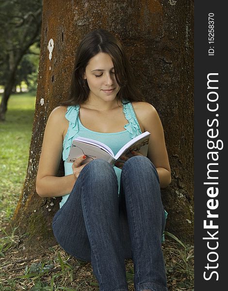 Young woman reading book in park