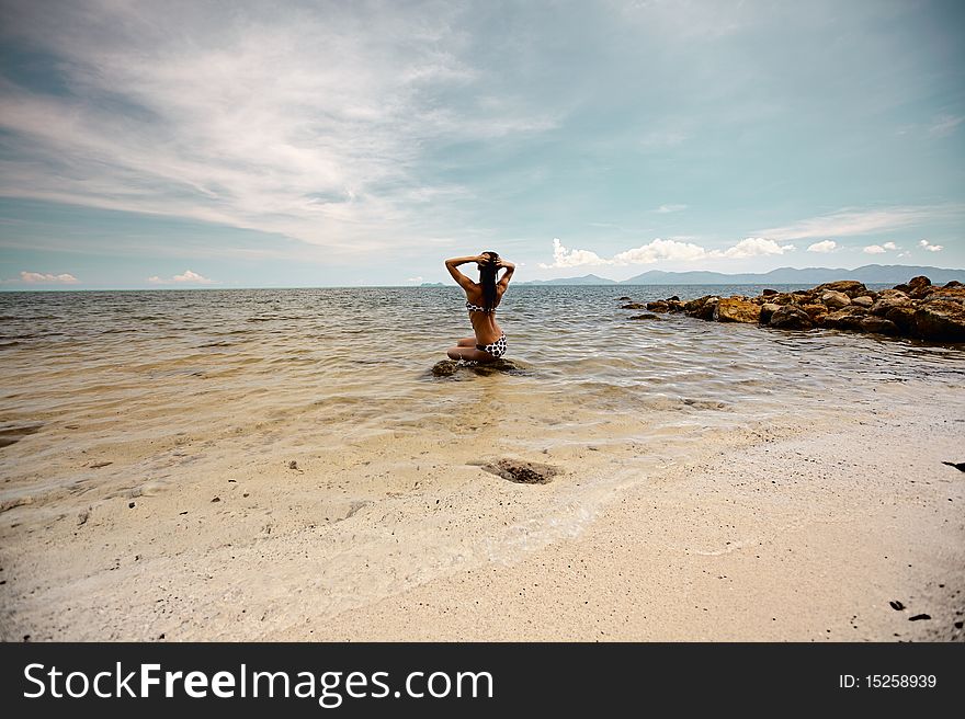 Woman siting on the ston in ocean. Woman siting on the ston in ocean...