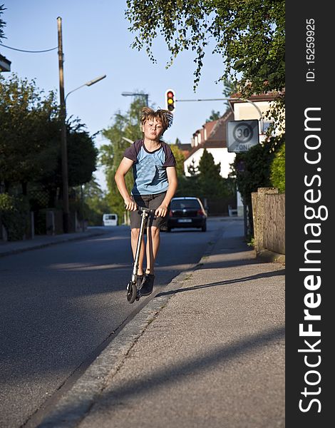 Boy with his scooter on the street