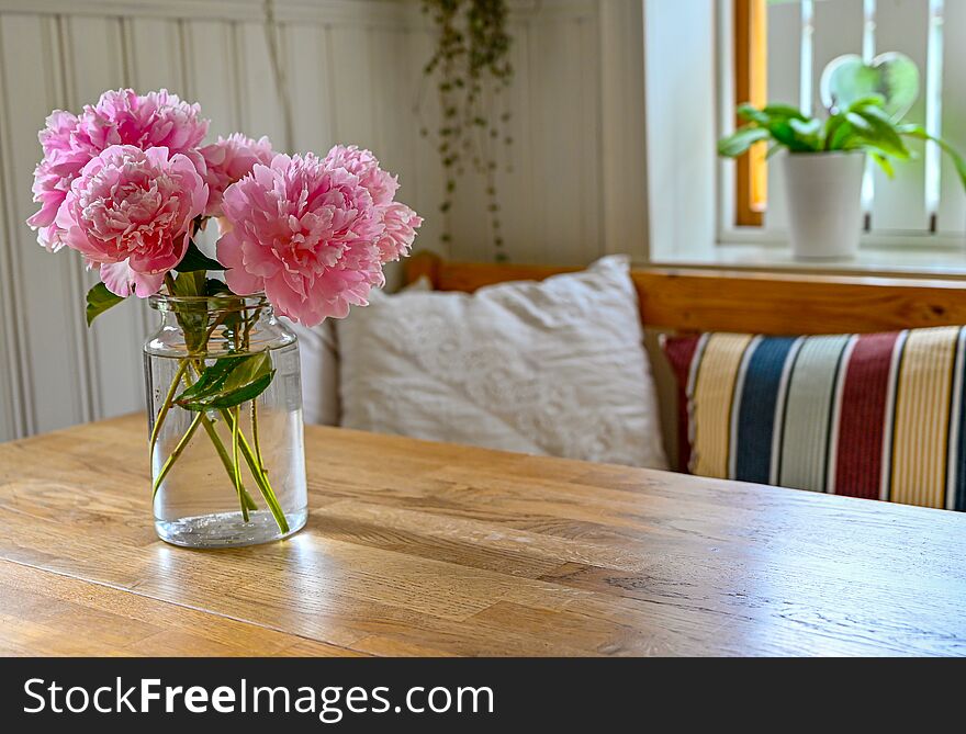 Big pink peony blossoms indoors in a kitchen