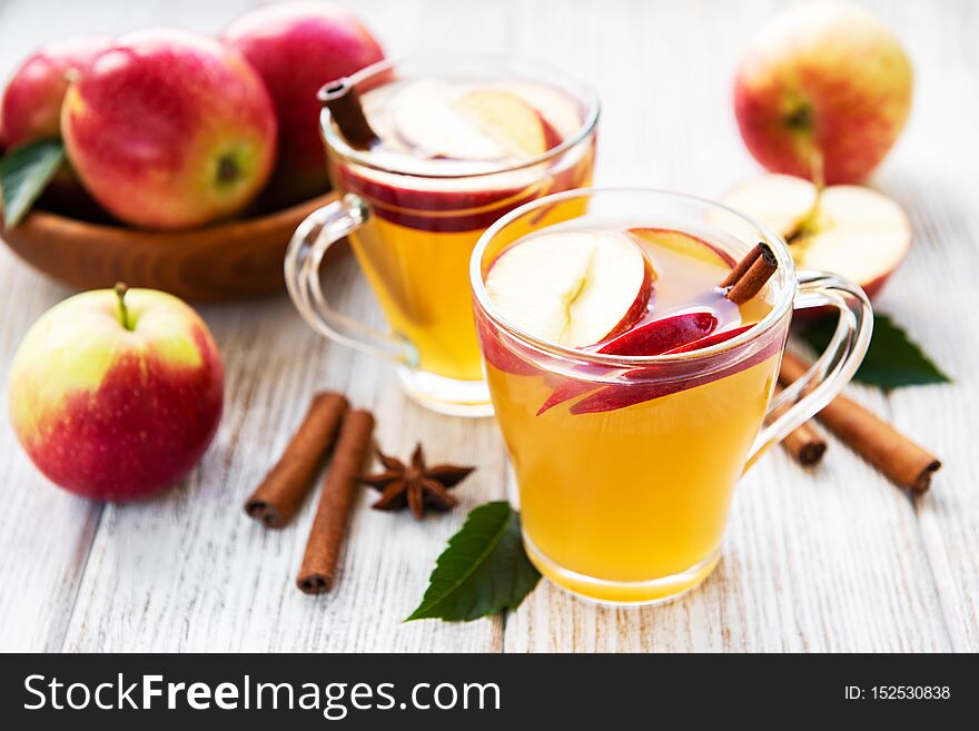 Apple cider with cinnamon sticks on a old wooden table. Apple cider with cinnamon sticks on a old wooden table
