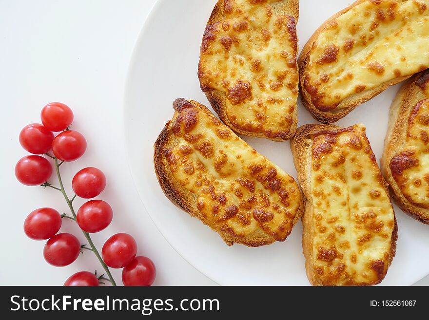 Roasted Cheese Toasts And Cherry Tmatoes In A White Plate