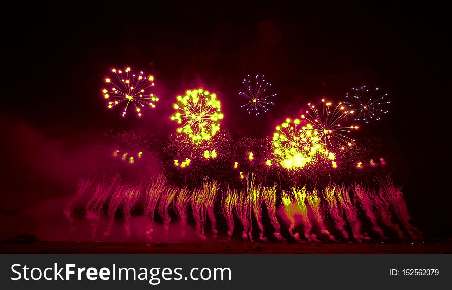Bright red and yellow balls of fireworks in th e night sky create a beautiful background. Bright red and yellow balls of fireworks in th e night sky create a beautiful background