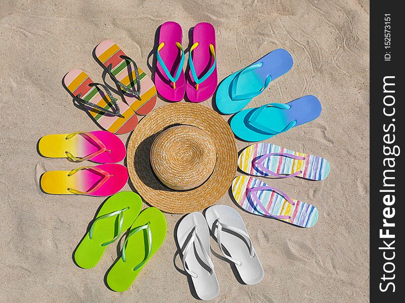 Flat lay composition with hat and flip flops on sand. Summer beach accessories