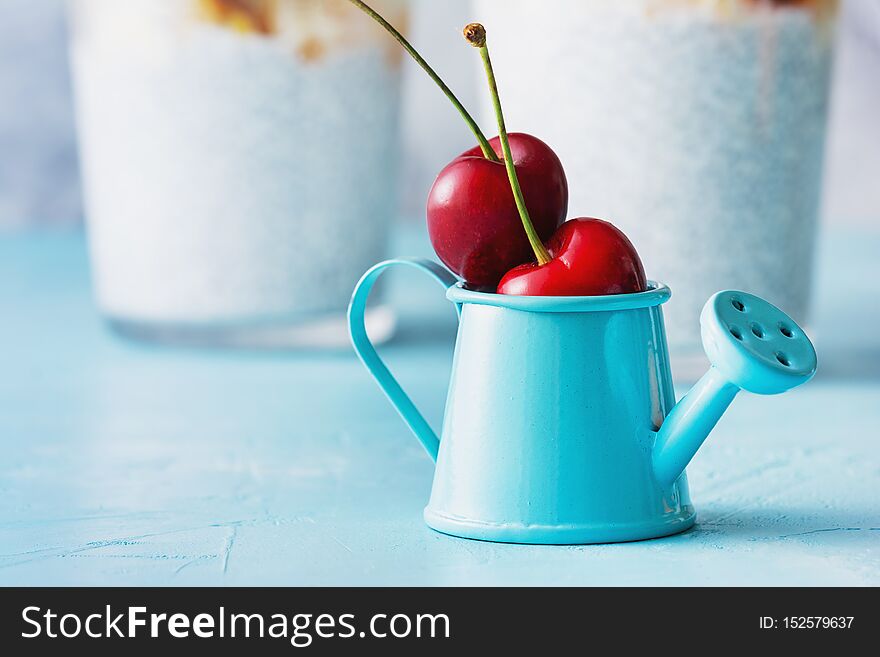 Mini Blue Watering Can with Two Ripe Cherry Fruit. Small Decorative Pot with Red Berry. Tiny Still Decoration with Fruity Ingredient. Natural Components for Diet Cocktail. Summer Garden Harvest